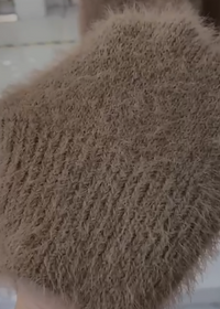 Zendaya Cardigan Close-up of a textured brown fabric with a blurred background