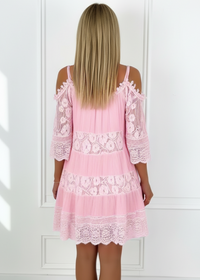 Pink lace dress worn by a person on a white background