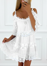 White lace dress worn by a person against a white wall