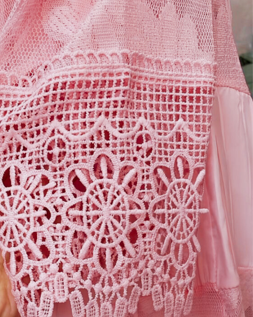 Close-up of a pink lace garment with intricate patterns.