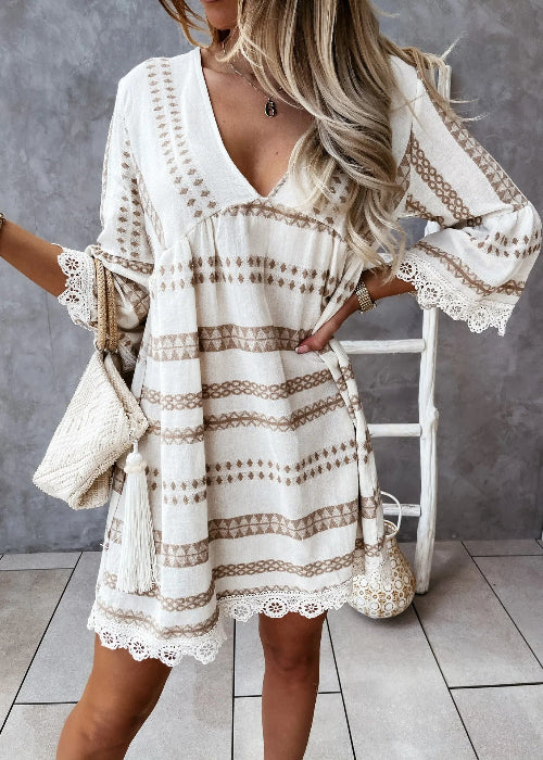 Woman wearing a white dress with lace details in an indoor setting.