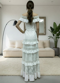 Woman wearing a white Alexa lace dress in a modern living room.
