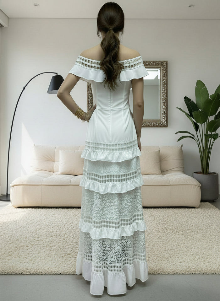 Woman wearing a white Alexa lace dress in a modern living room.