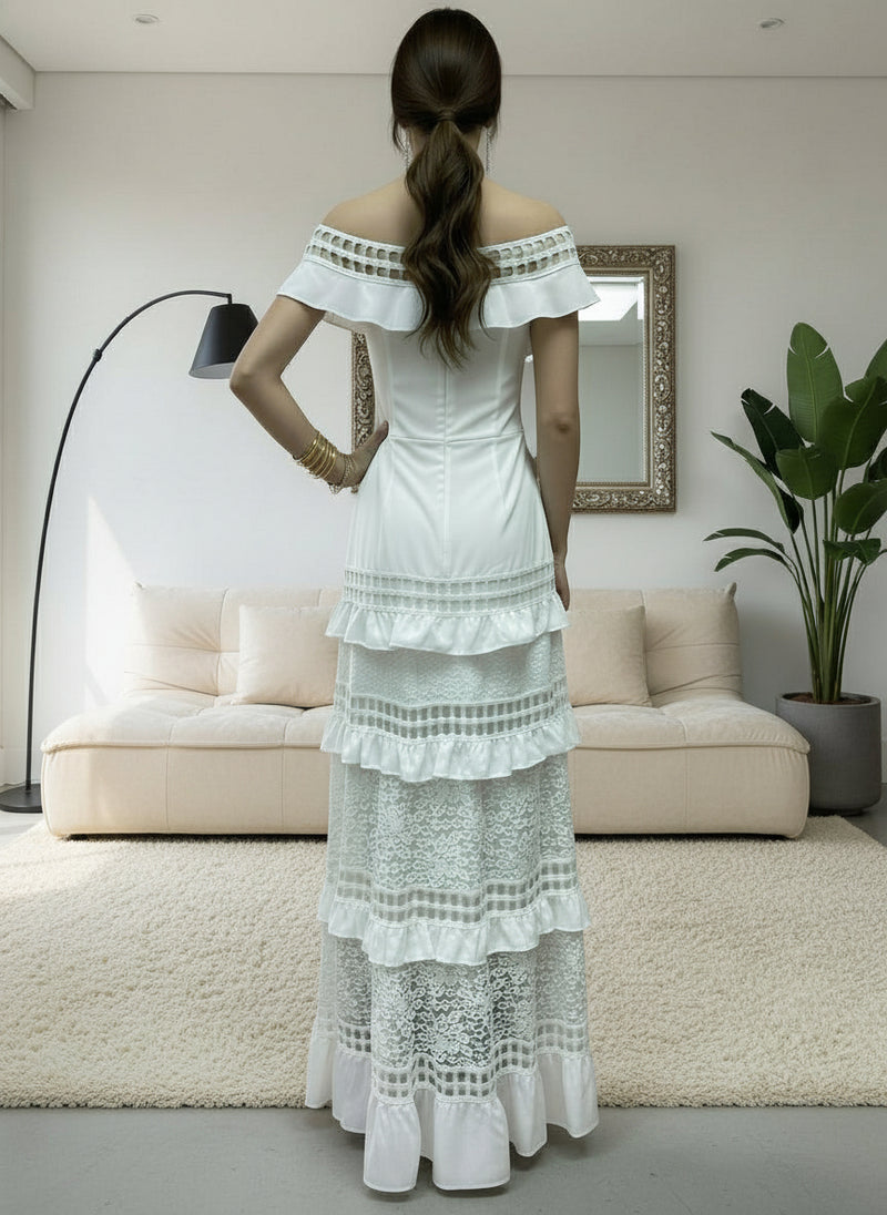 Woman wearing a white Alexa lace dress in a modern living room.